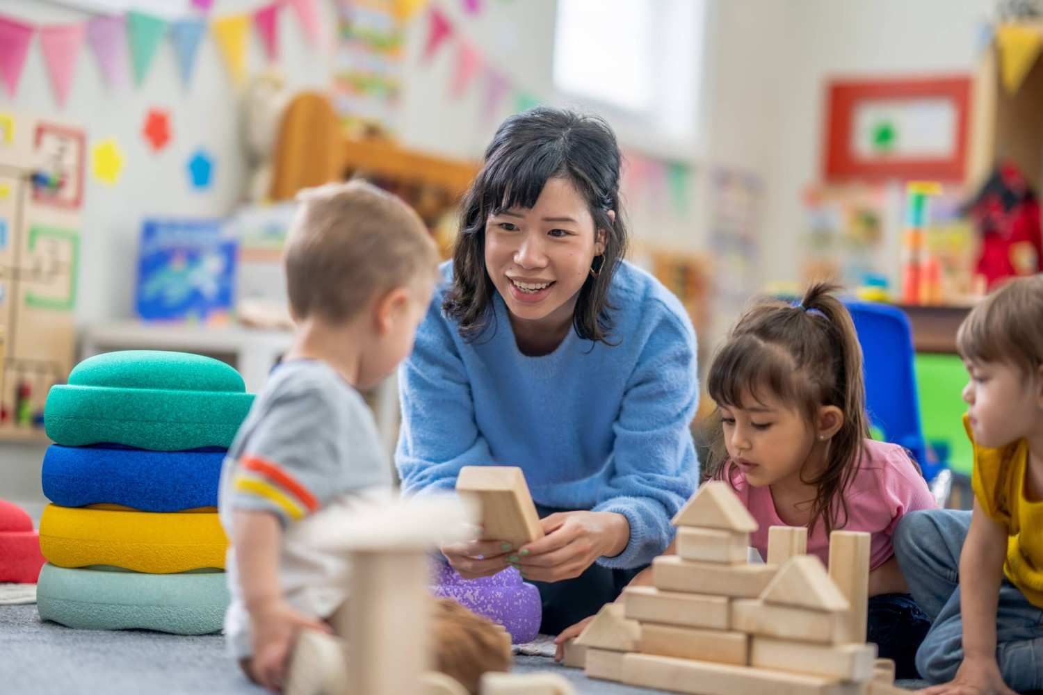 Childcare trainer and two students looking at a tablet together